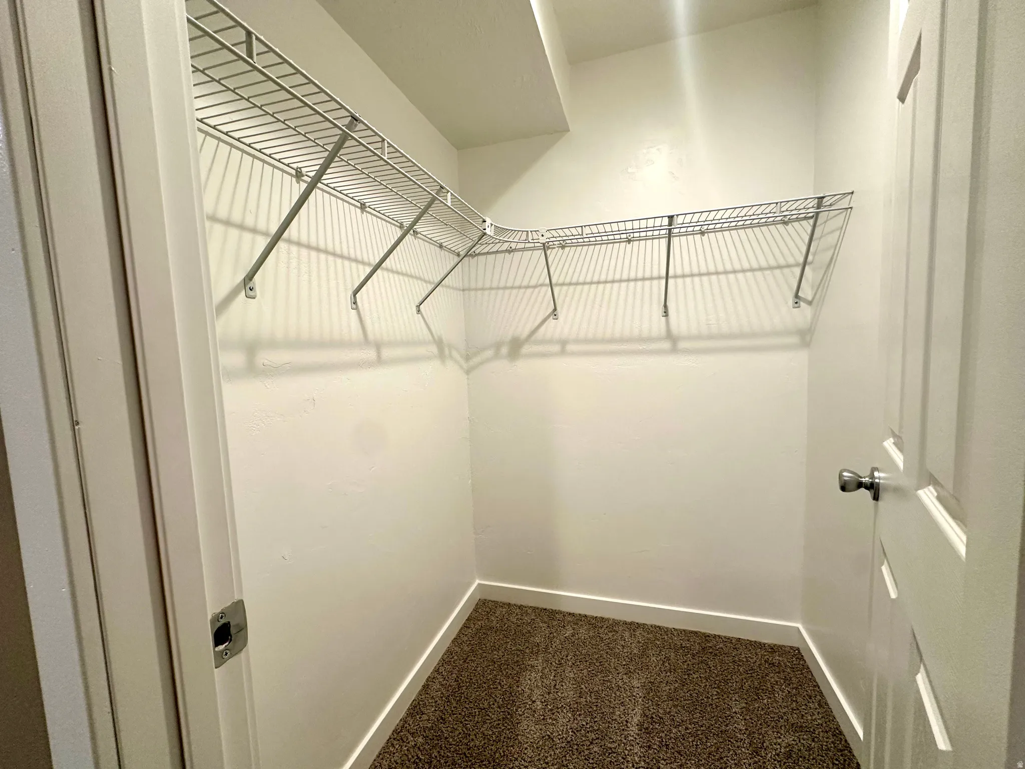 4th Bedroom Walk in closet with dark colored carpet