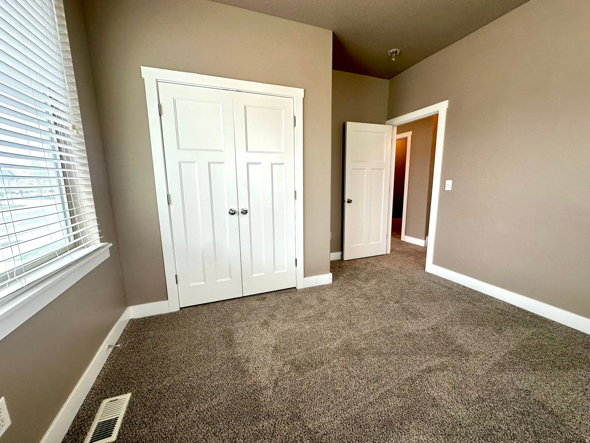 Unfurnished bedroom with dark colored carpet and a closet
