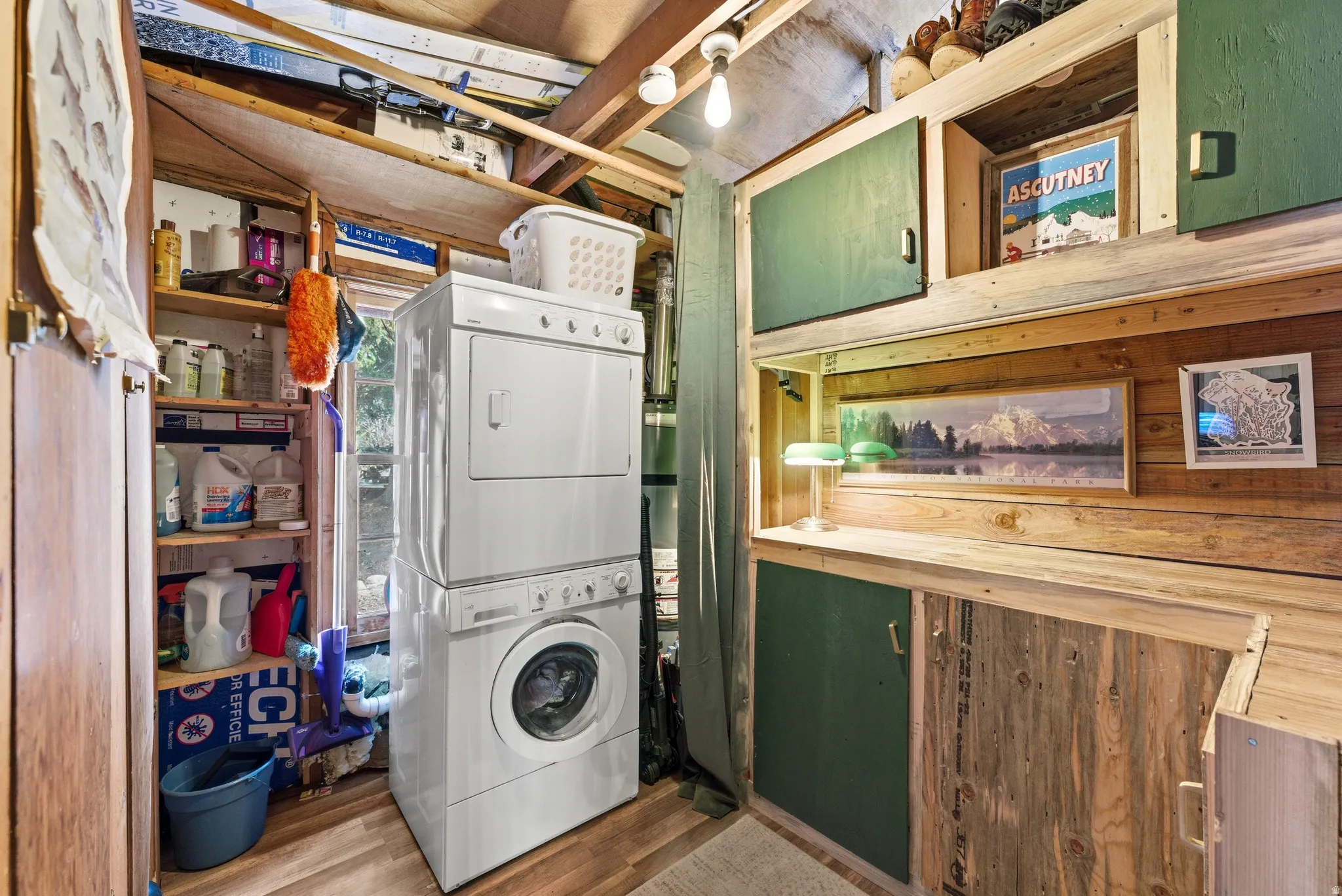 Laundry area featuring stacked washer / drying machine and dark wood-type flooring