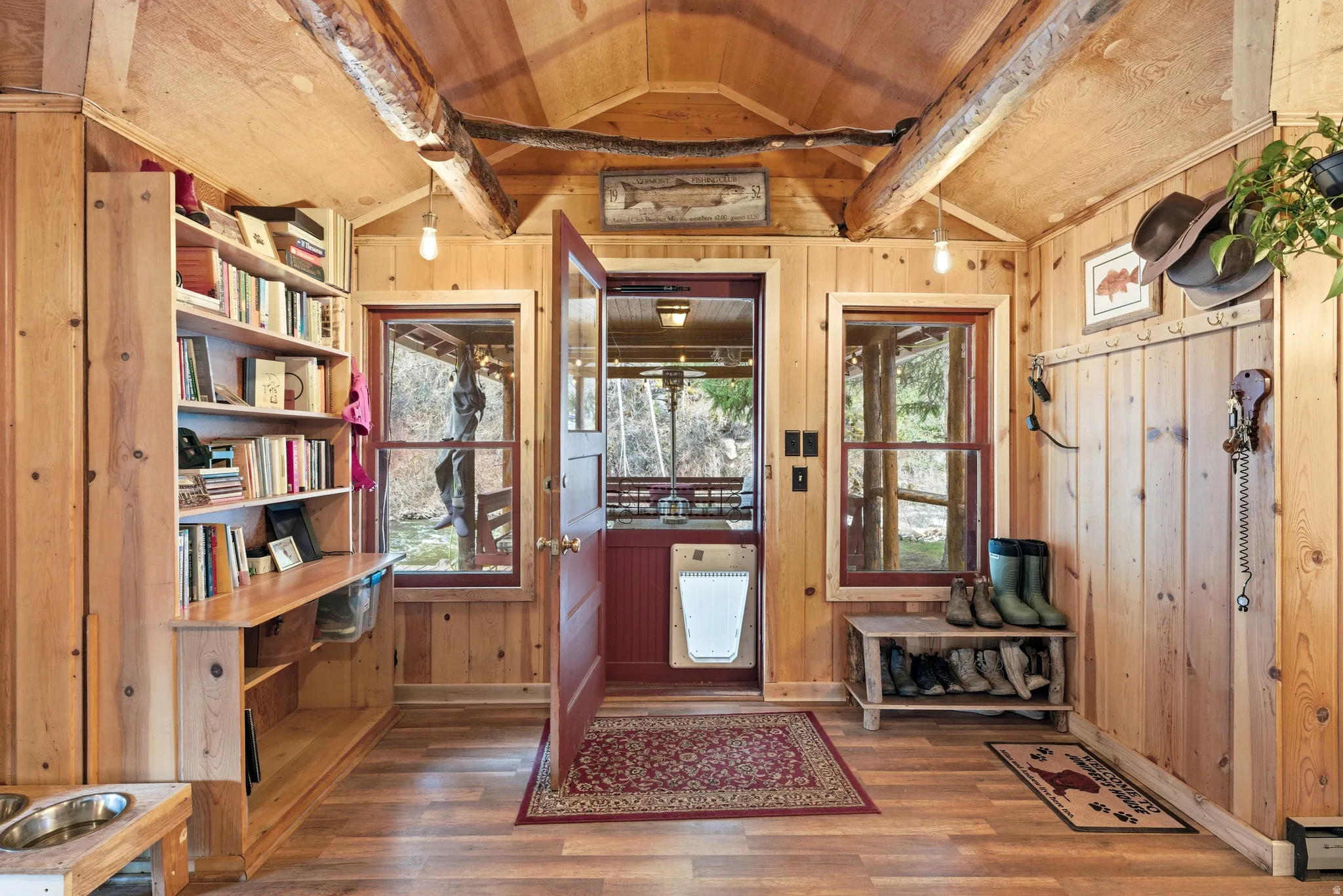 Entryway featuring dark wood-type flooring, plenty of natural light, wooden walls, and wooden ceiling