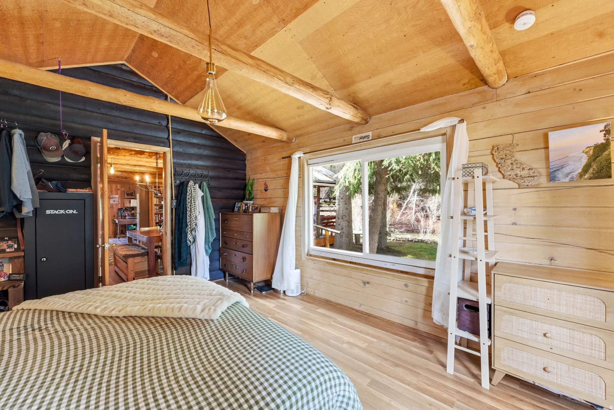 Bedroom featuring wood-type flooring, vaulted ceiling with beams, rustic walls, wooden ceiling, and a closet