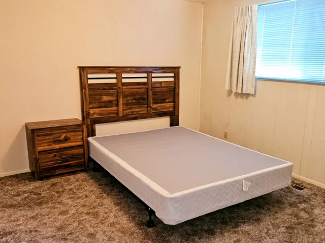Bedroom featuring baseboards and dark carpet