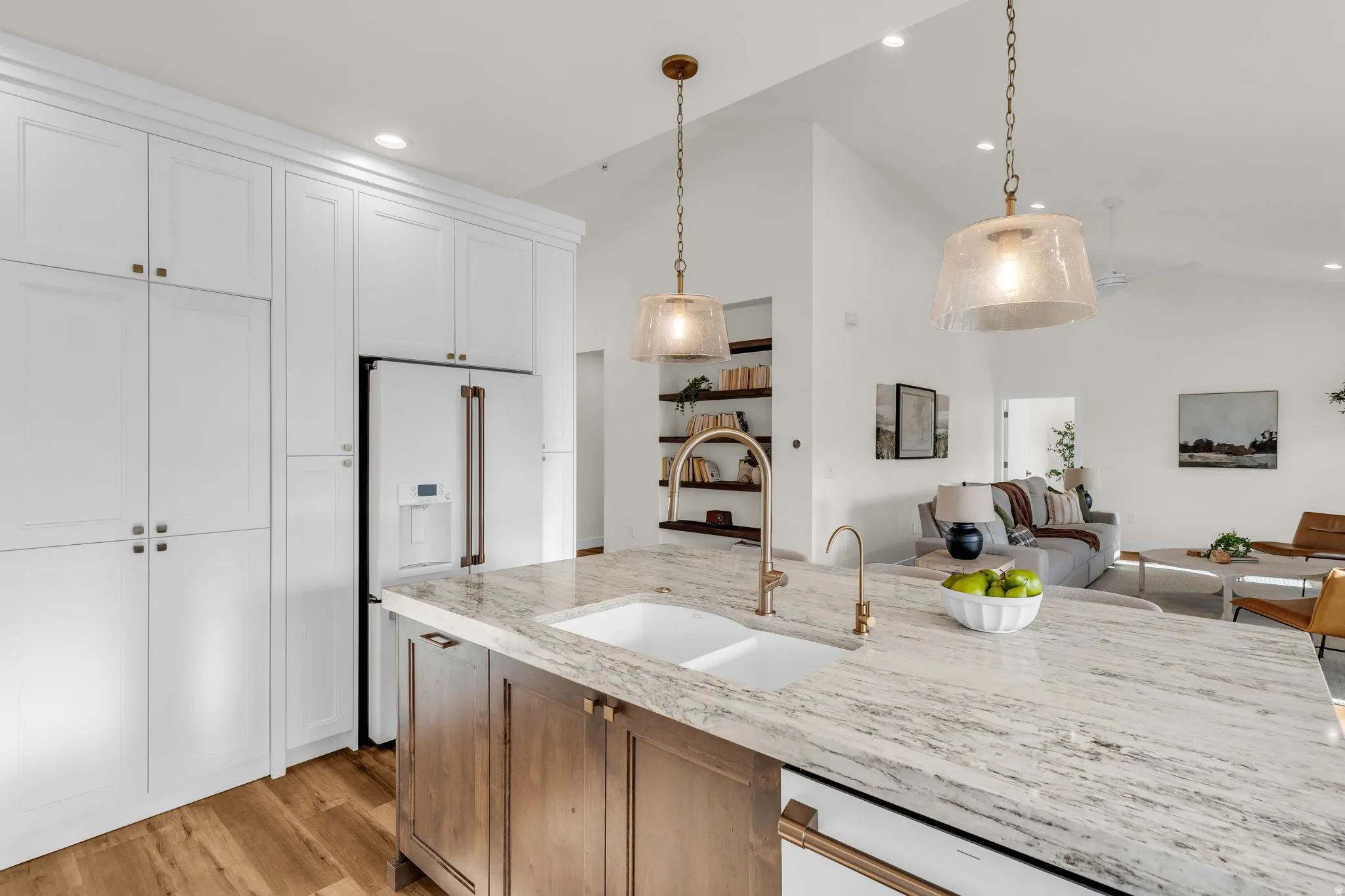Kitchen with light stone counters, lofted ceiling, high end white fridge, open floor plan, and light wood finished floors