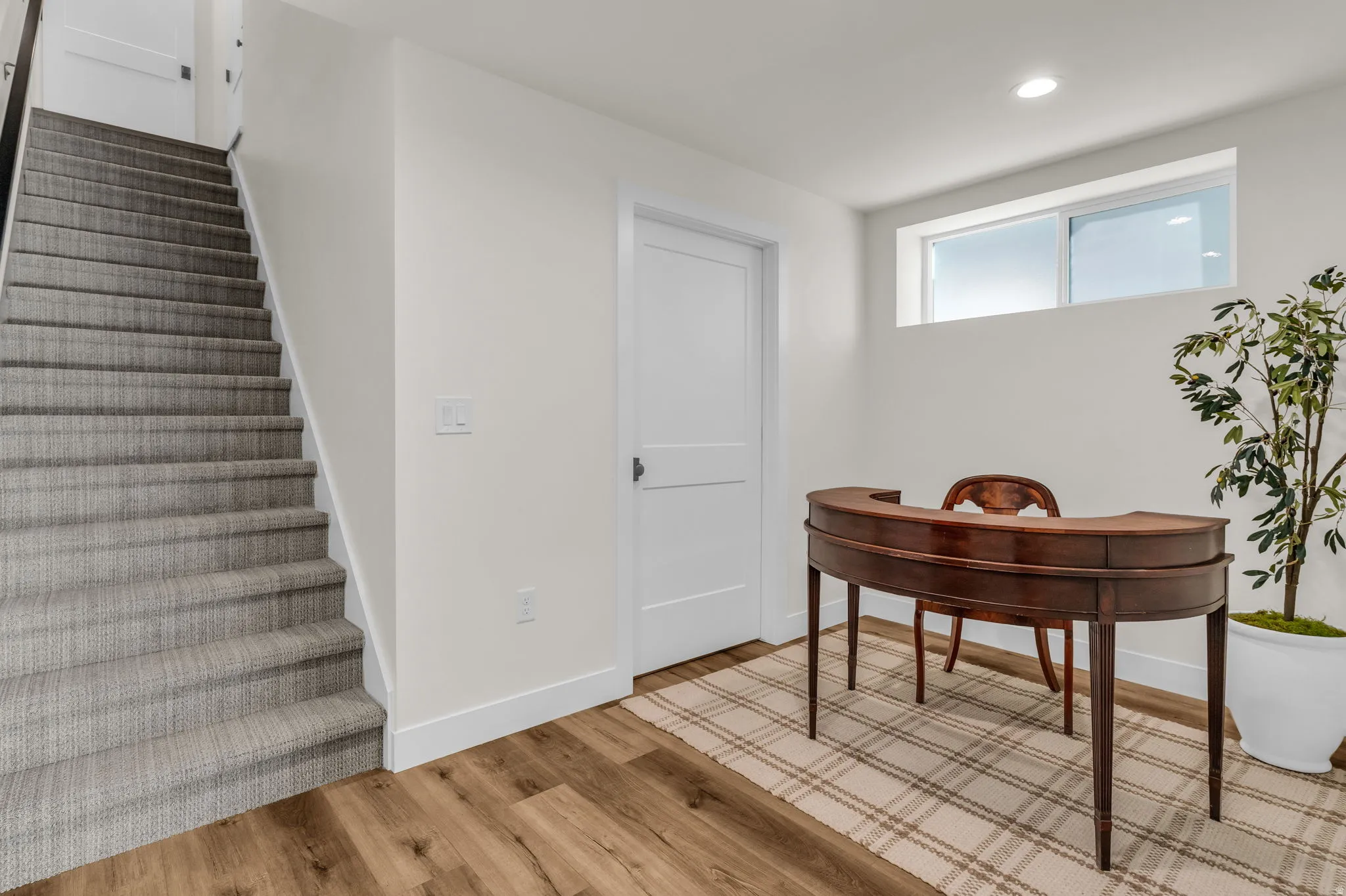 Stairs with wood finished floors and recessed lighting