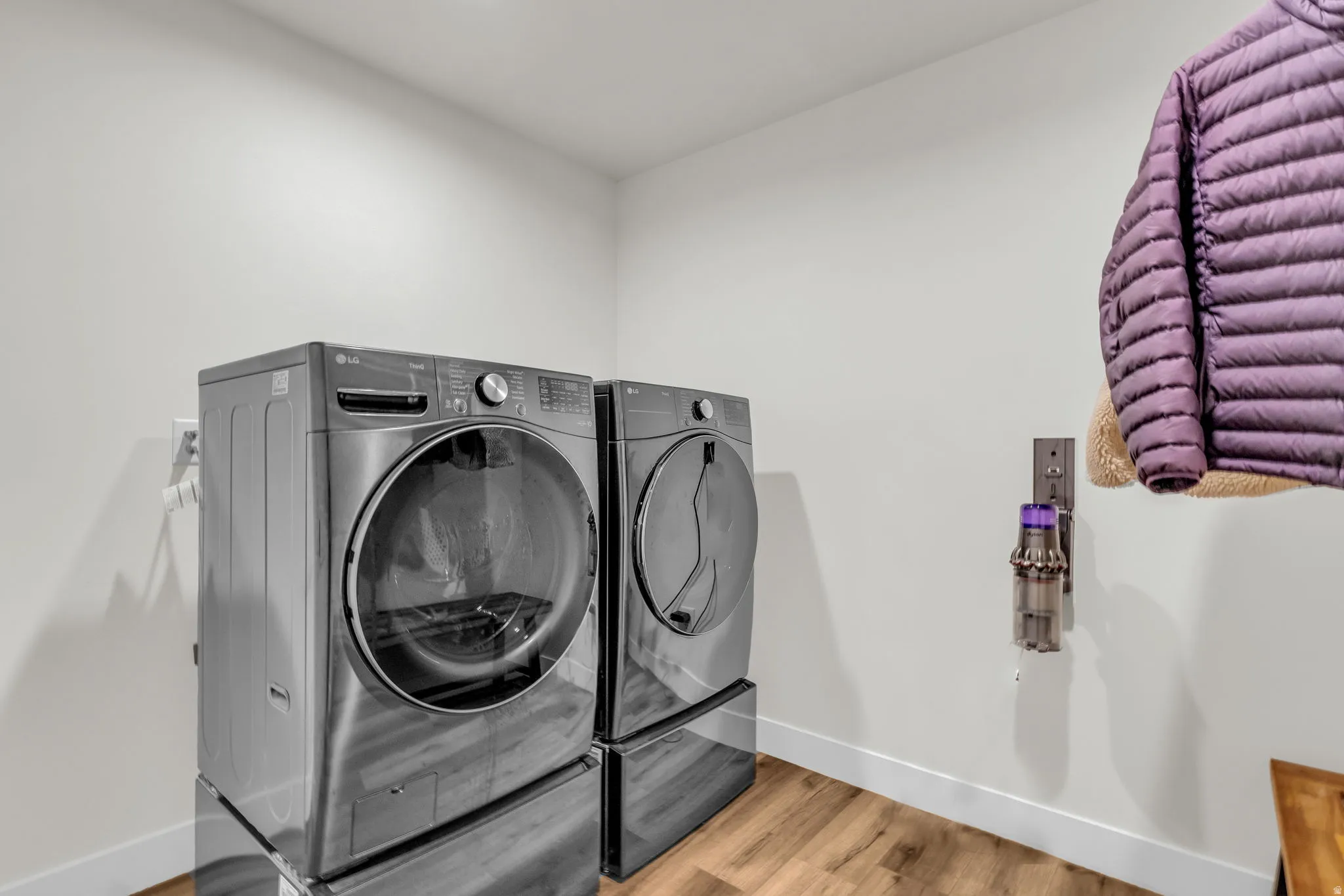 Laundry room featuring light wood finished floors and washing machine and dryer