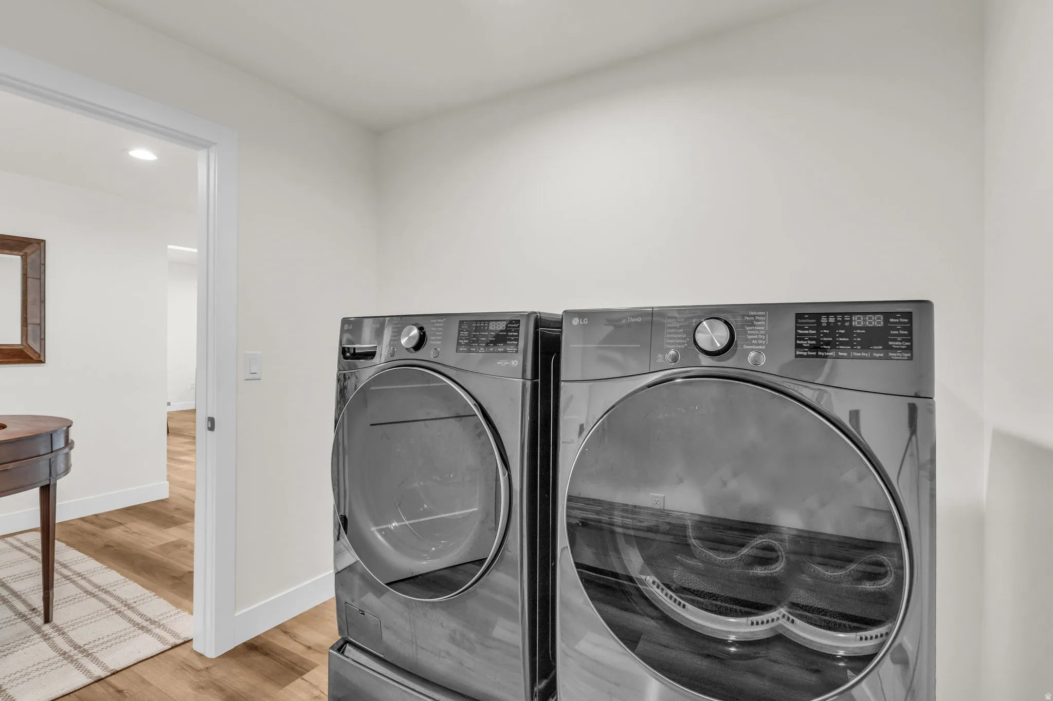 Laundry room featuring light wood-style flooring, recessed lighting, and washing machine and clothes dryer