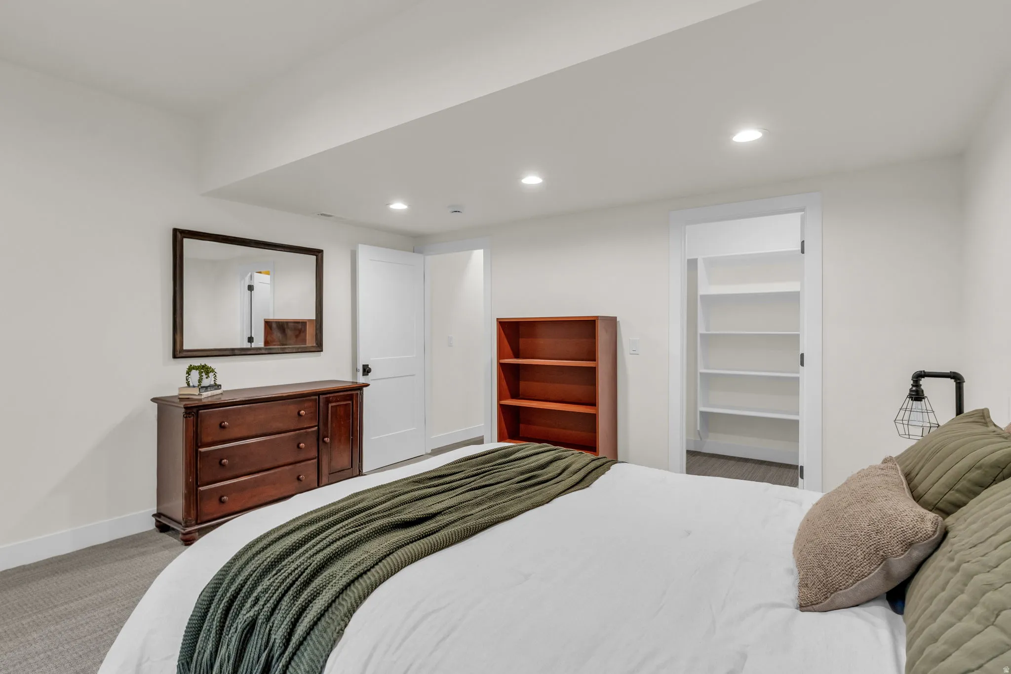 Carpeted bedroom featuring a spacious closet and recessed lighting