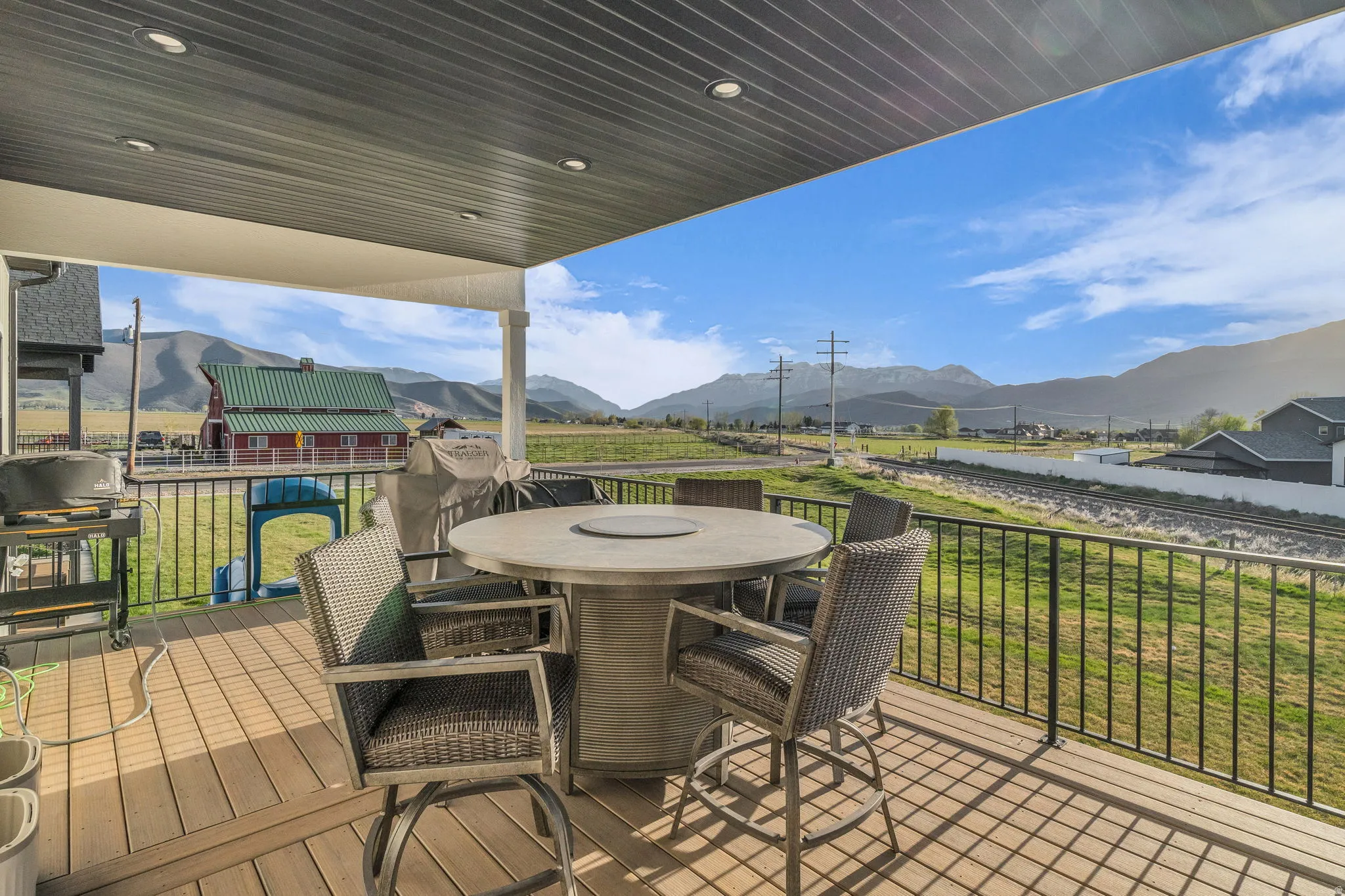 Wooden terrace featuring a mountain view, outdoor dining area, a yard, and grilling area