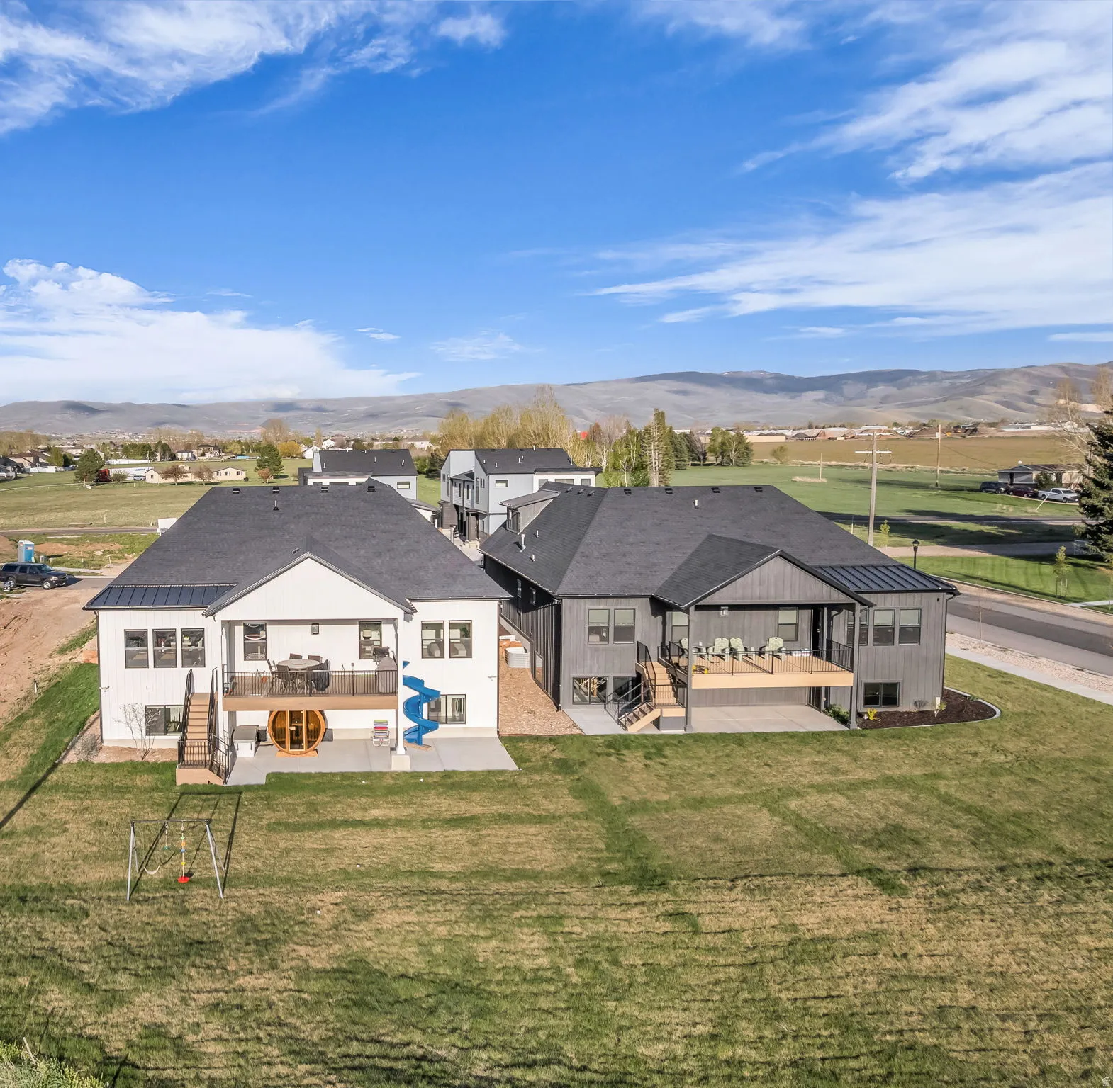Rear view of house with a patio, a mountain view, and a lawn