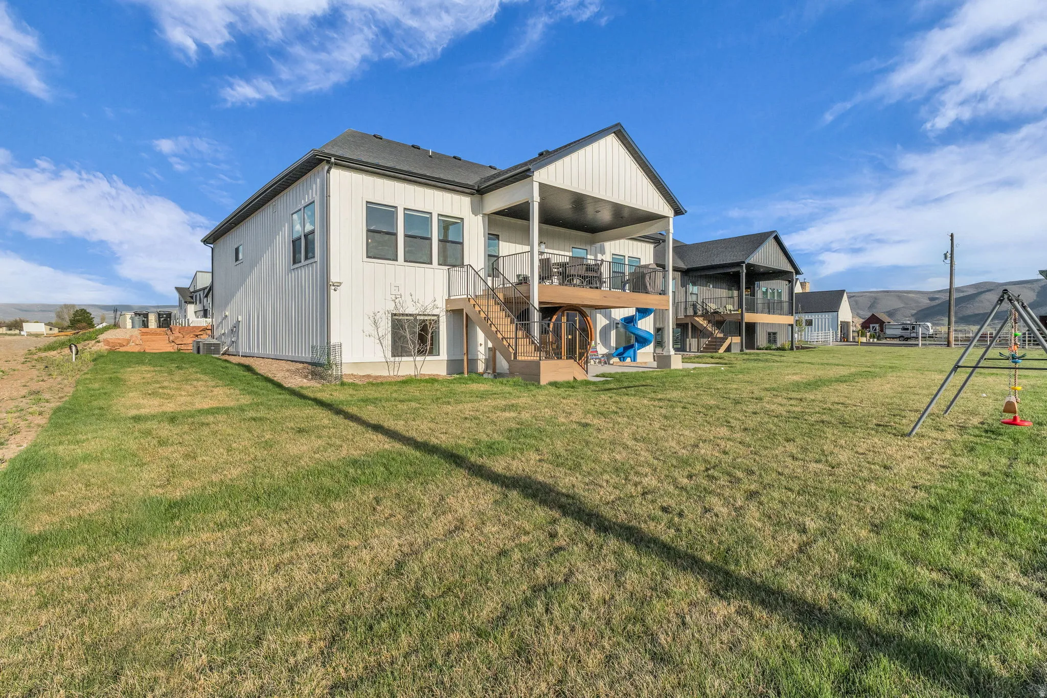 Rear view of property with a patio area, a lawn, and a playground