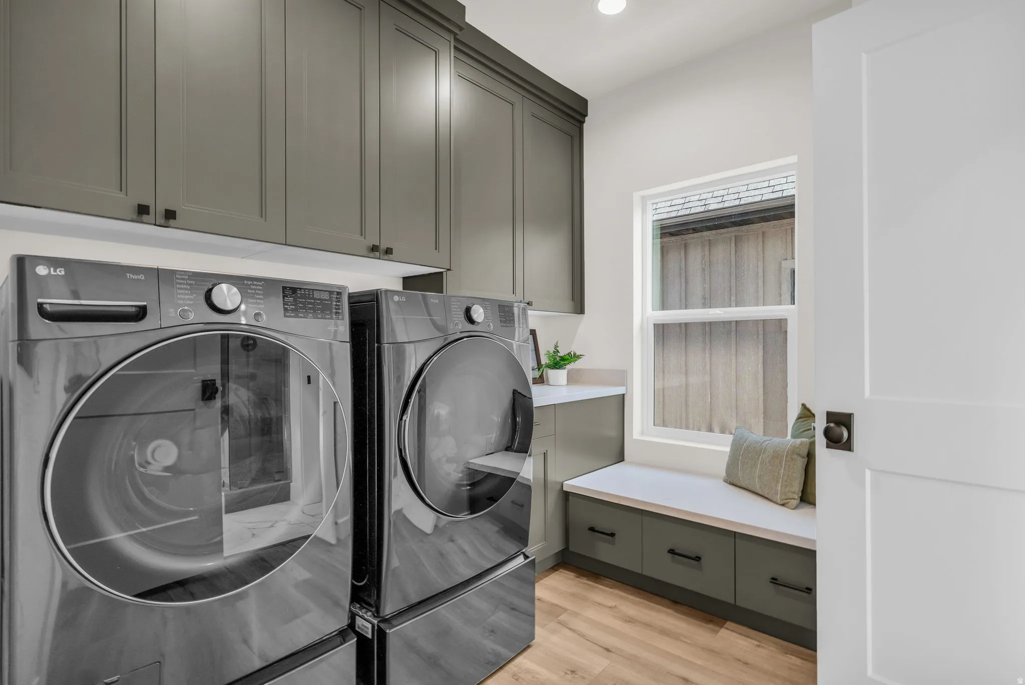 Laundry room featuring washer and clothes dryer, light wood-style flooring, cabinet space, and recessed lighting