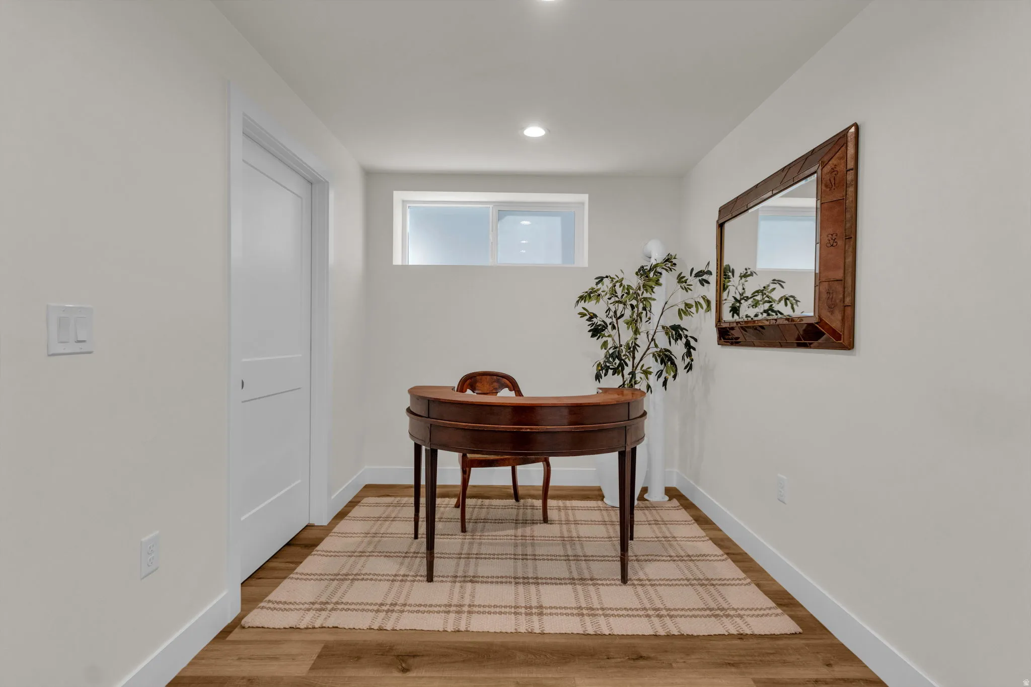 Hallway with light wood-style flooring and recessed lighting