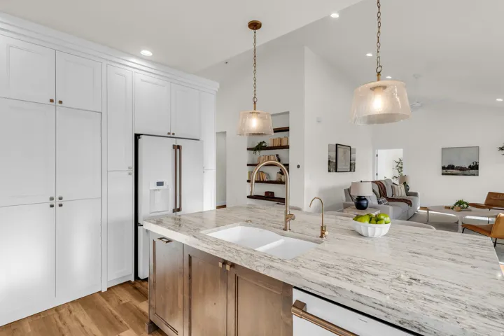 Kitchen with light stone counters, lofted ceiling, high end white fridge, open floor plan, and light wood finished floors