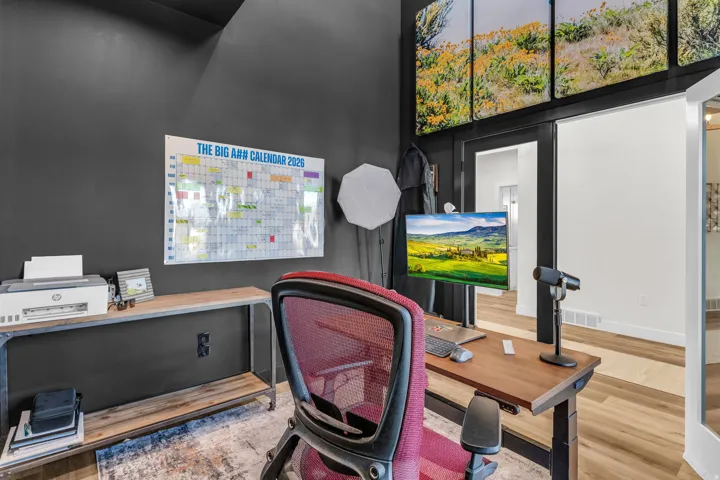 Office area featuring wood finished floors and a high ceiling