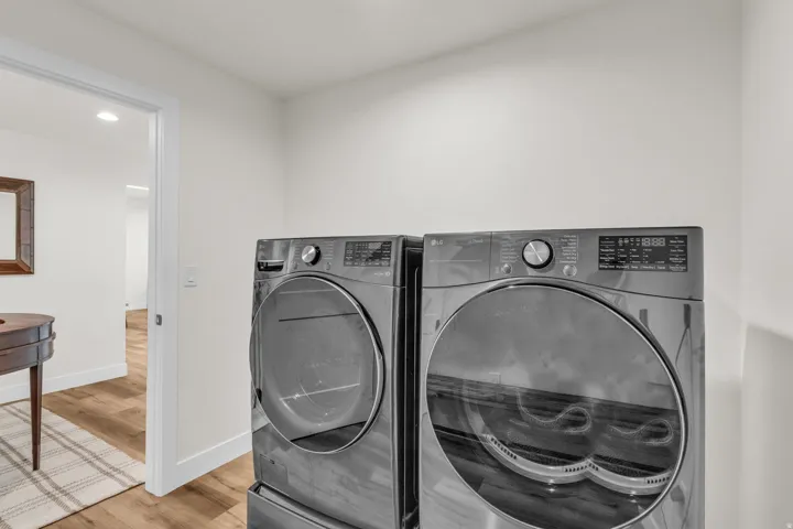 Laundry room featuring light wood-style flooring, recessed lighting, and washing machine and clothes dryer