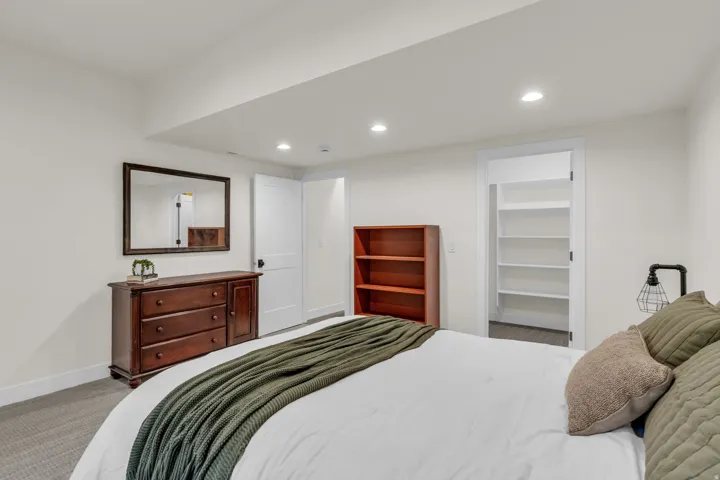 Carpeted bedroom featuring a spacious closet and recessed lighting