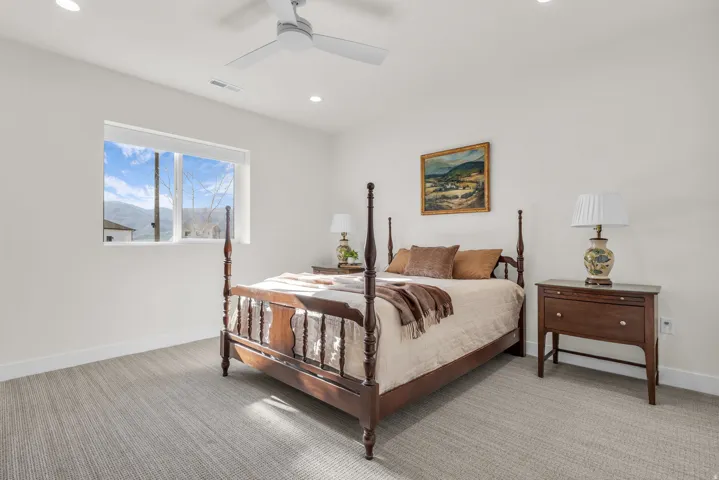 Bedroom with light carpet, a ceiling fan, and recessed lighting