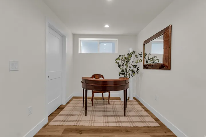 Hallway with light wood-style flooring and recessed lighting