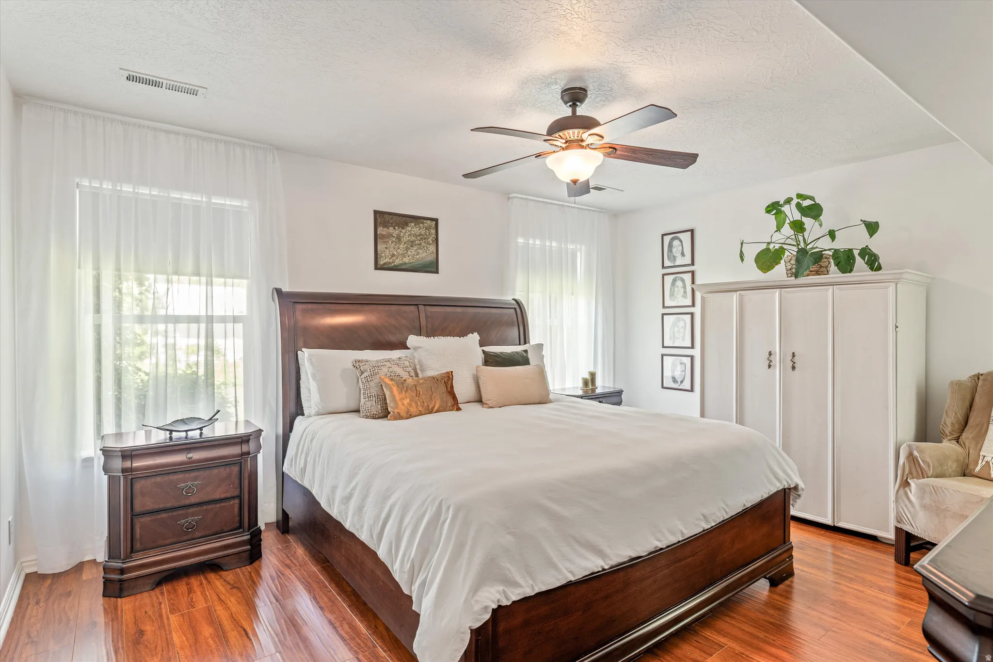 Bedroom featuring a textured ceiling, dark wood finished floors, and ceiling fan