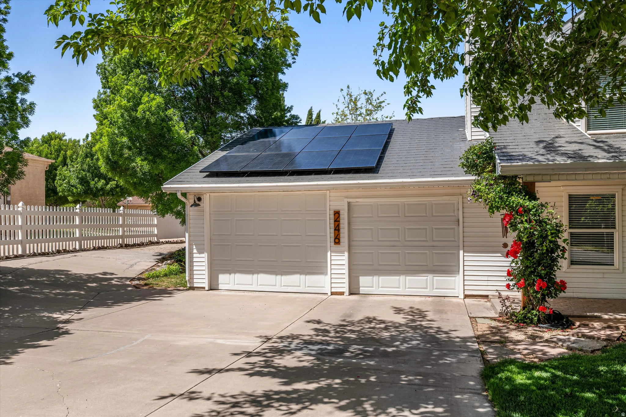 Garage featuring solar panels and driveway