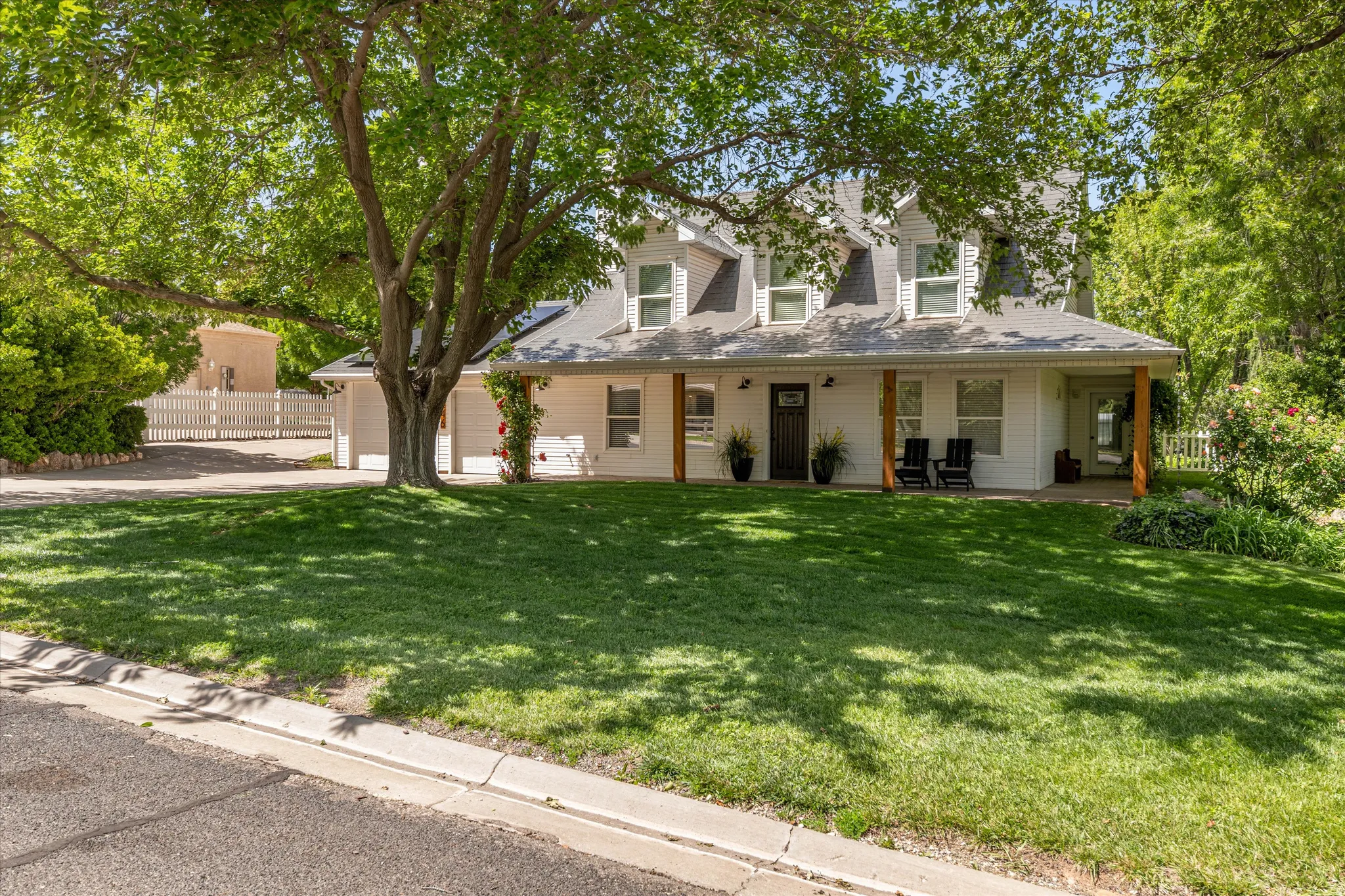Cape cod house with concrete driveway, a porch, and a garage