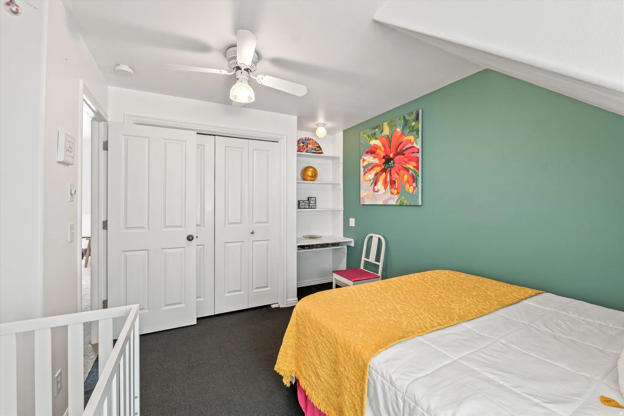 Bedroom with dark carpet, a closet, and ceiling fan