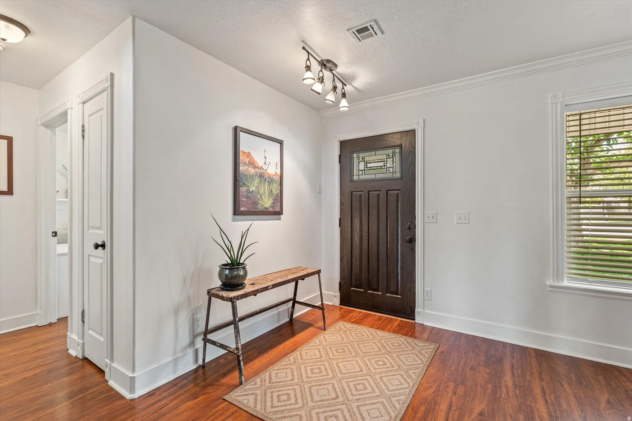 Entryway featuring wood finished floors, plenty of natural light, and a textured ceiling