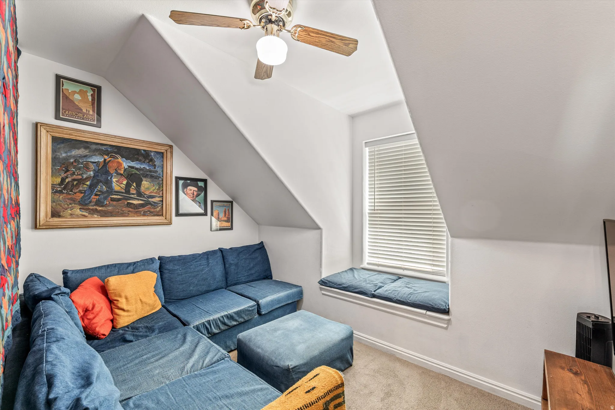 Living area with carpet floors, lofted ceiling, and ceiling fan