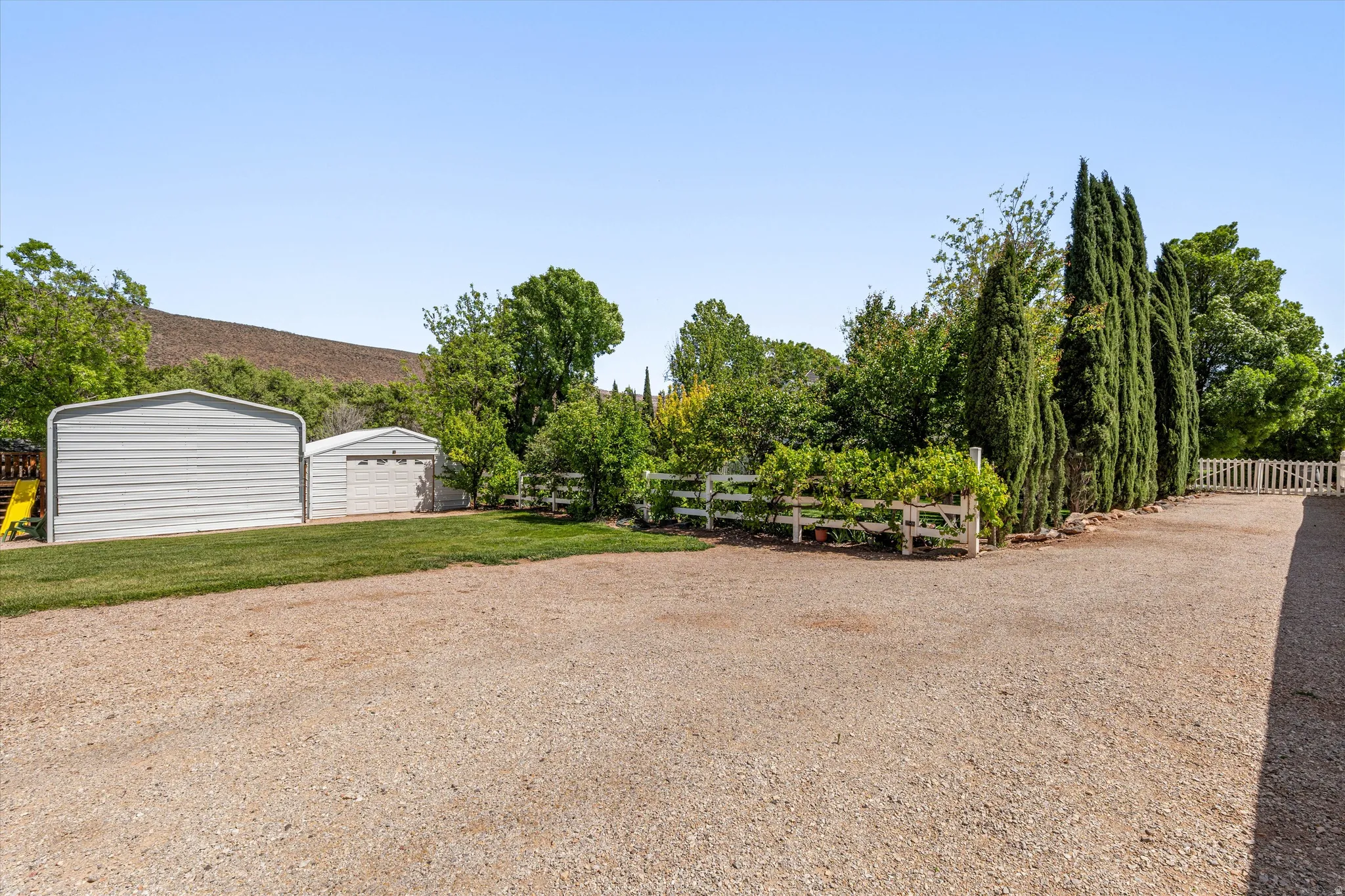 View of yard with an outdoor structure, a garage, and driveway