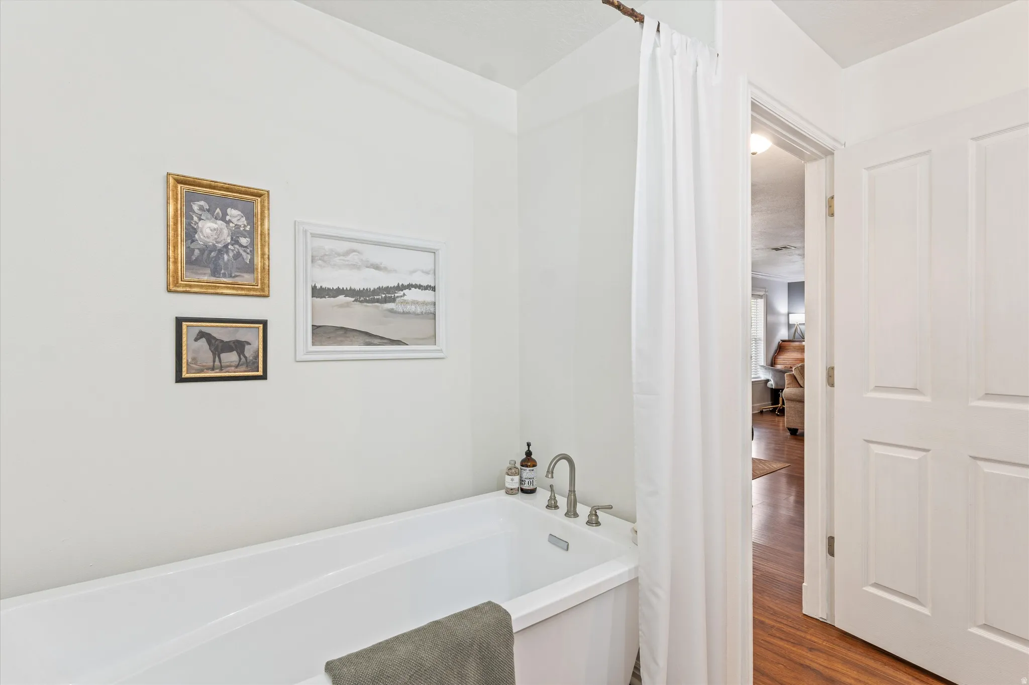 Full bathroom with a garden tub and wood finished floors