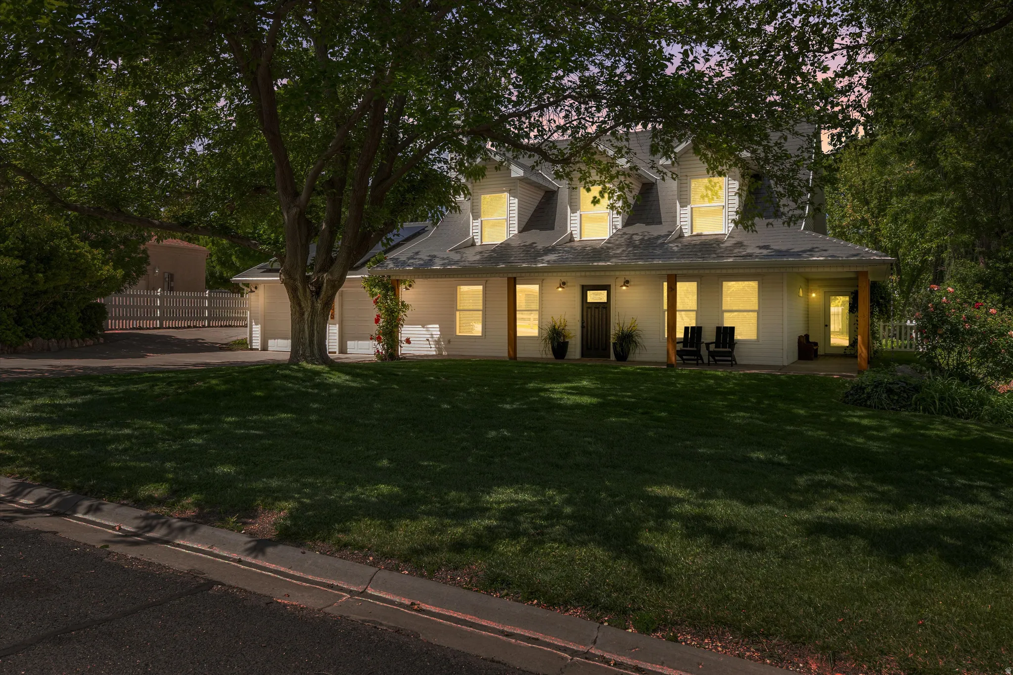 View of front of property featuring a porch, concrete driveway, and an attached garage