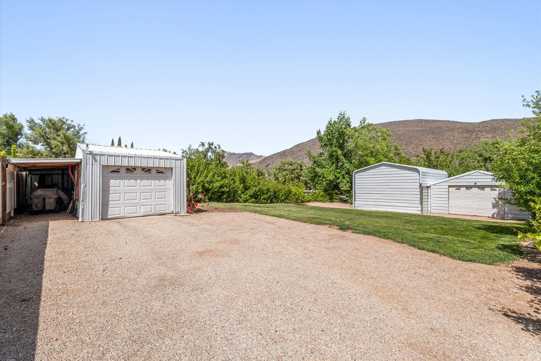 Detached garage with a mountain view and gravel driveway
