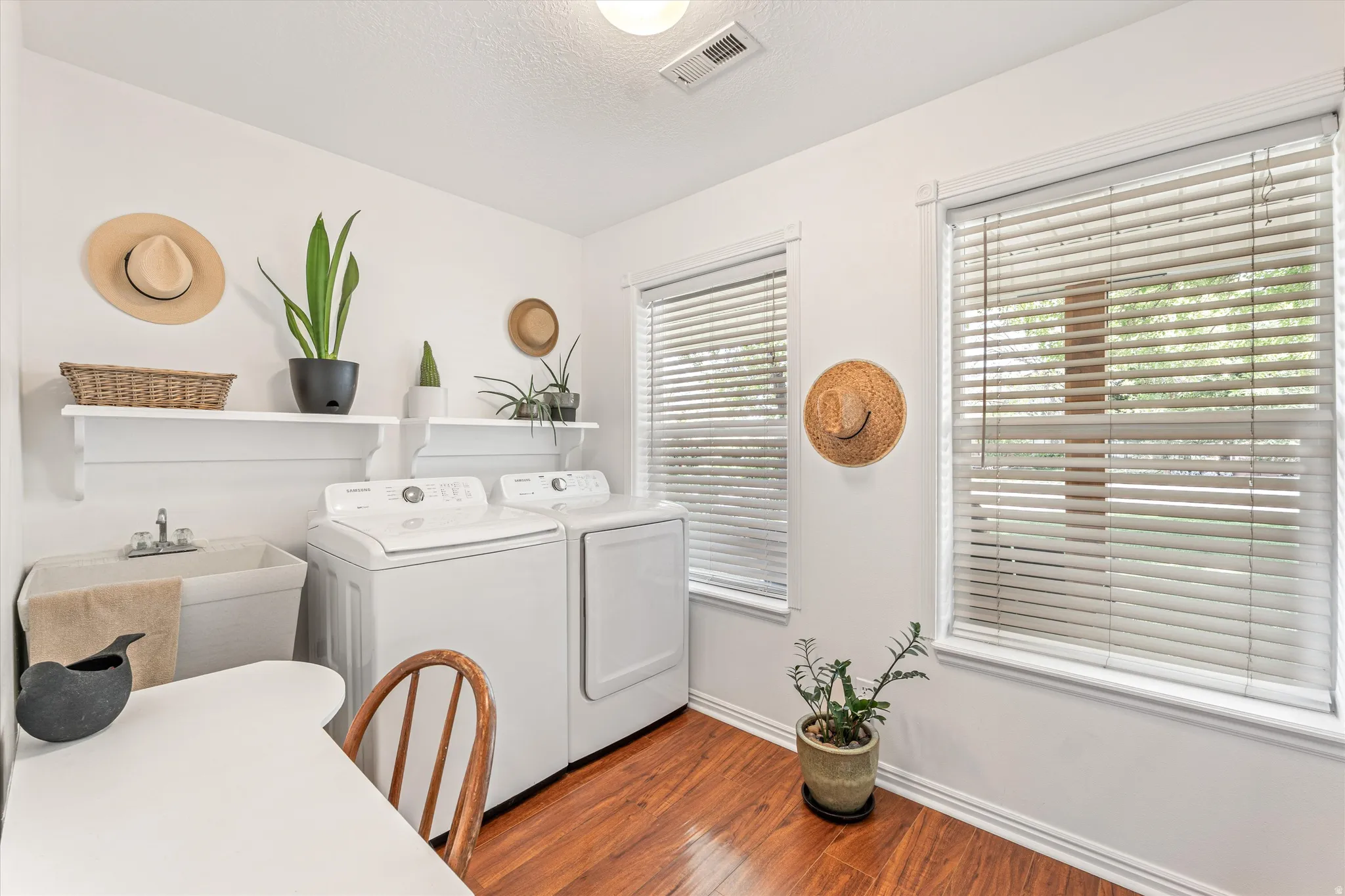Laundry room featuring washing machine and dryer, dark wood-style flooring, and a textured ceiling