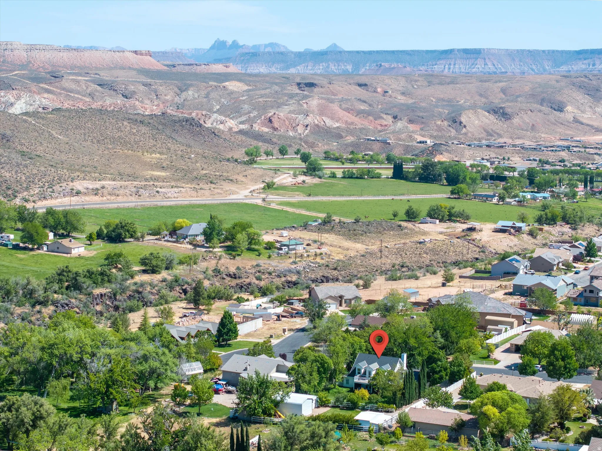 Aerial view of property's location with a mountainous background and nearby suburban area