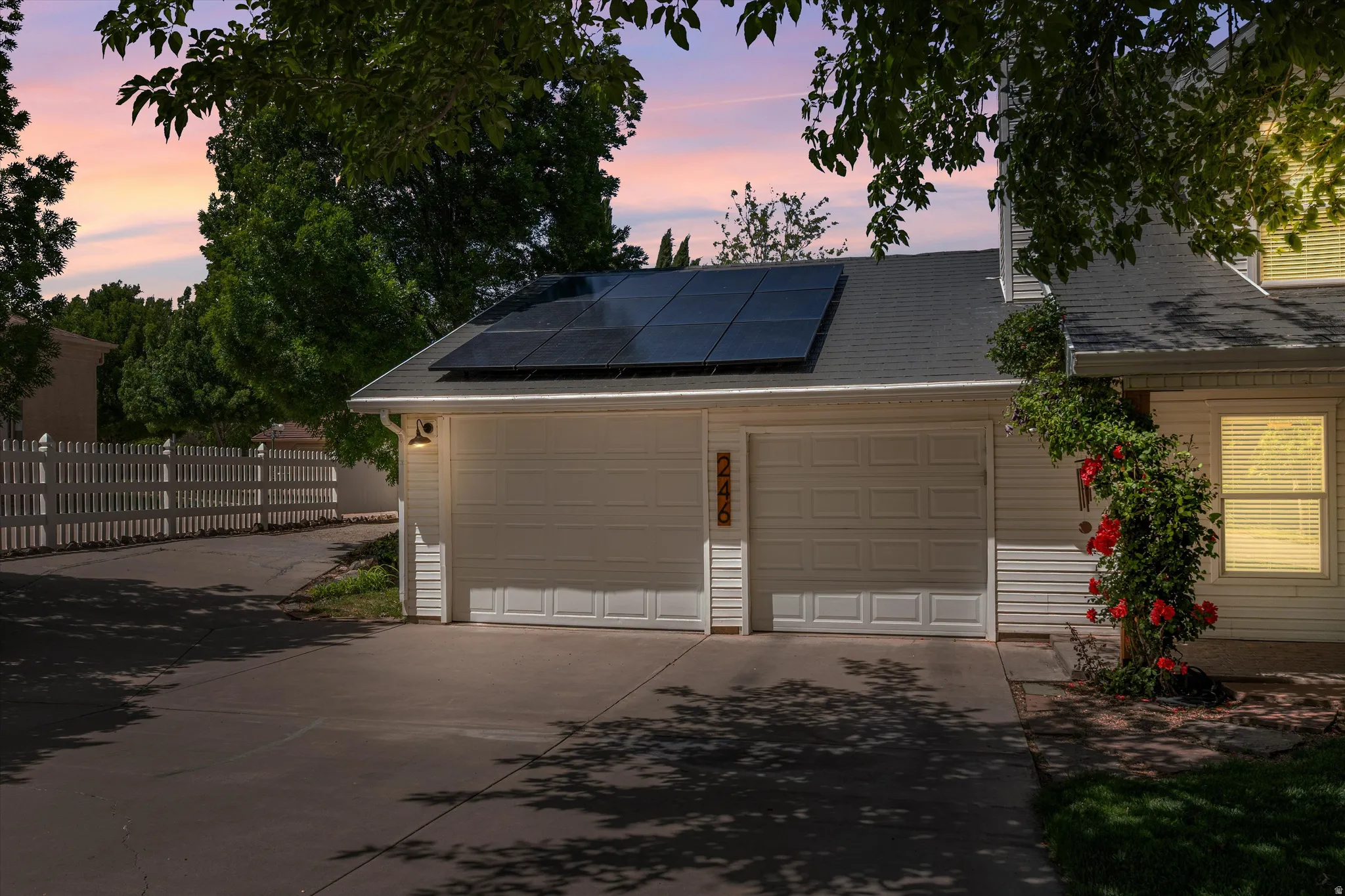 Garage with solar panels and concrete driveway