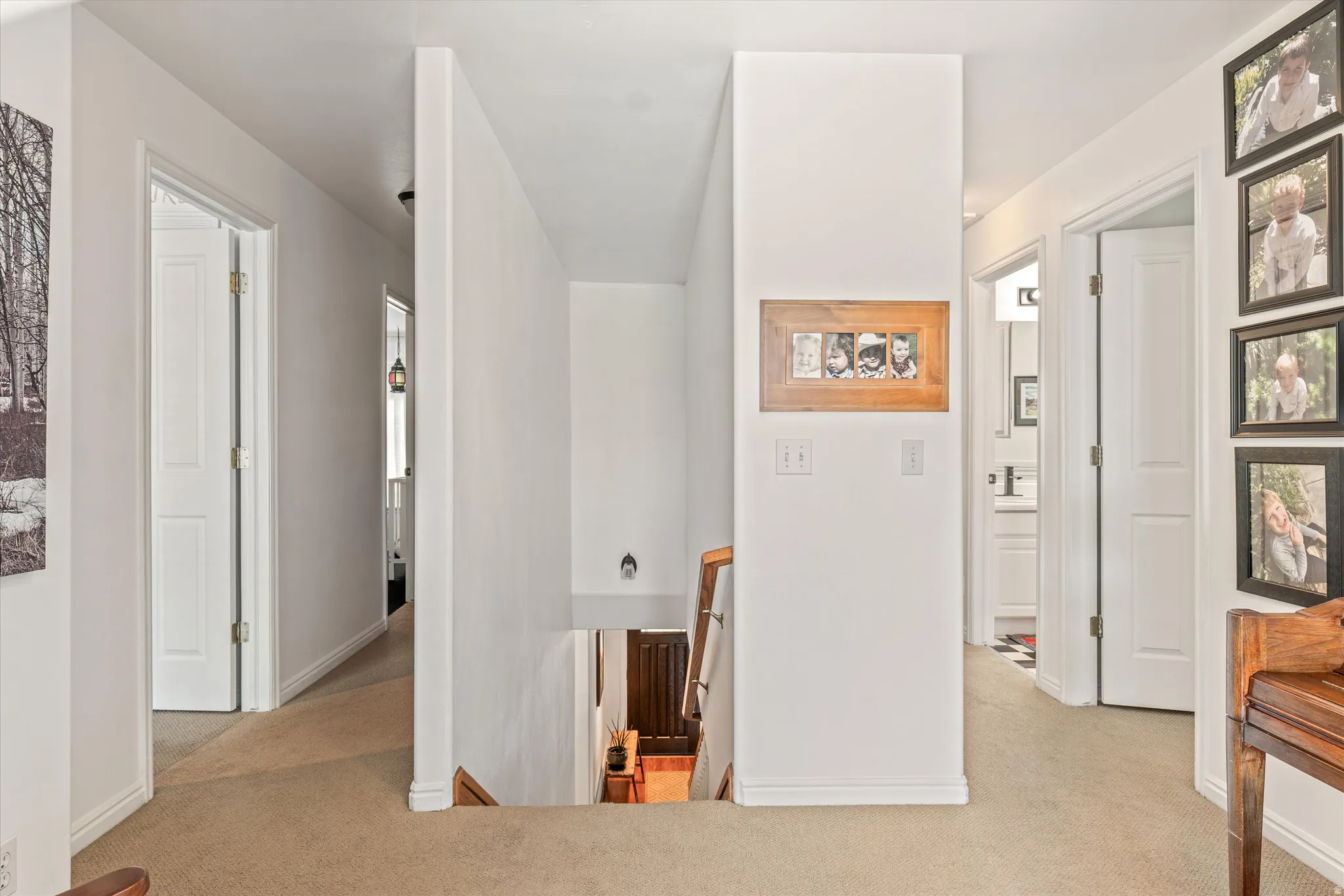 Hallway featuring an upstairs landing and light colored carpet