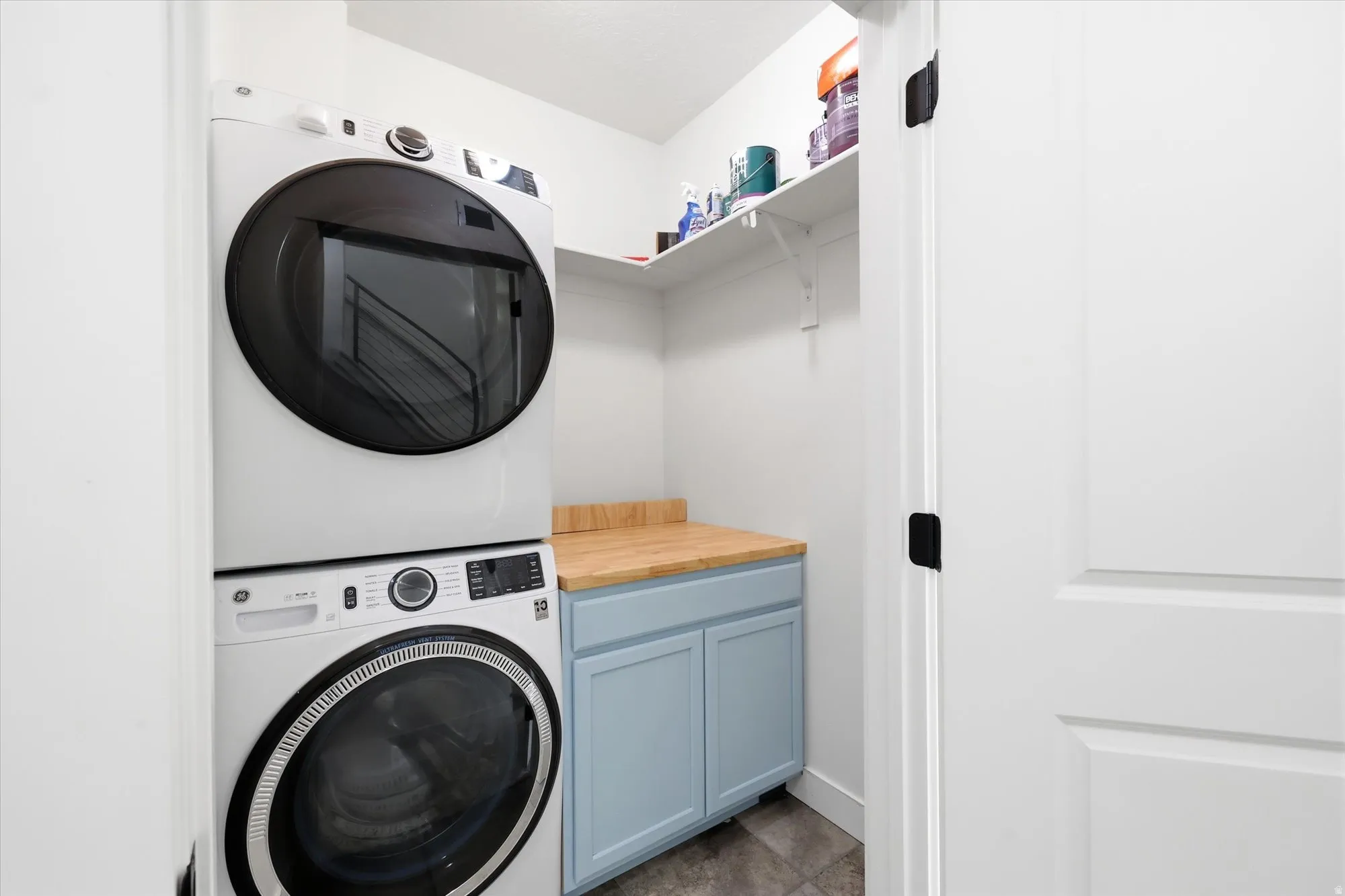 Laundry room featuring stacked washing machine and dryer and cabinet space