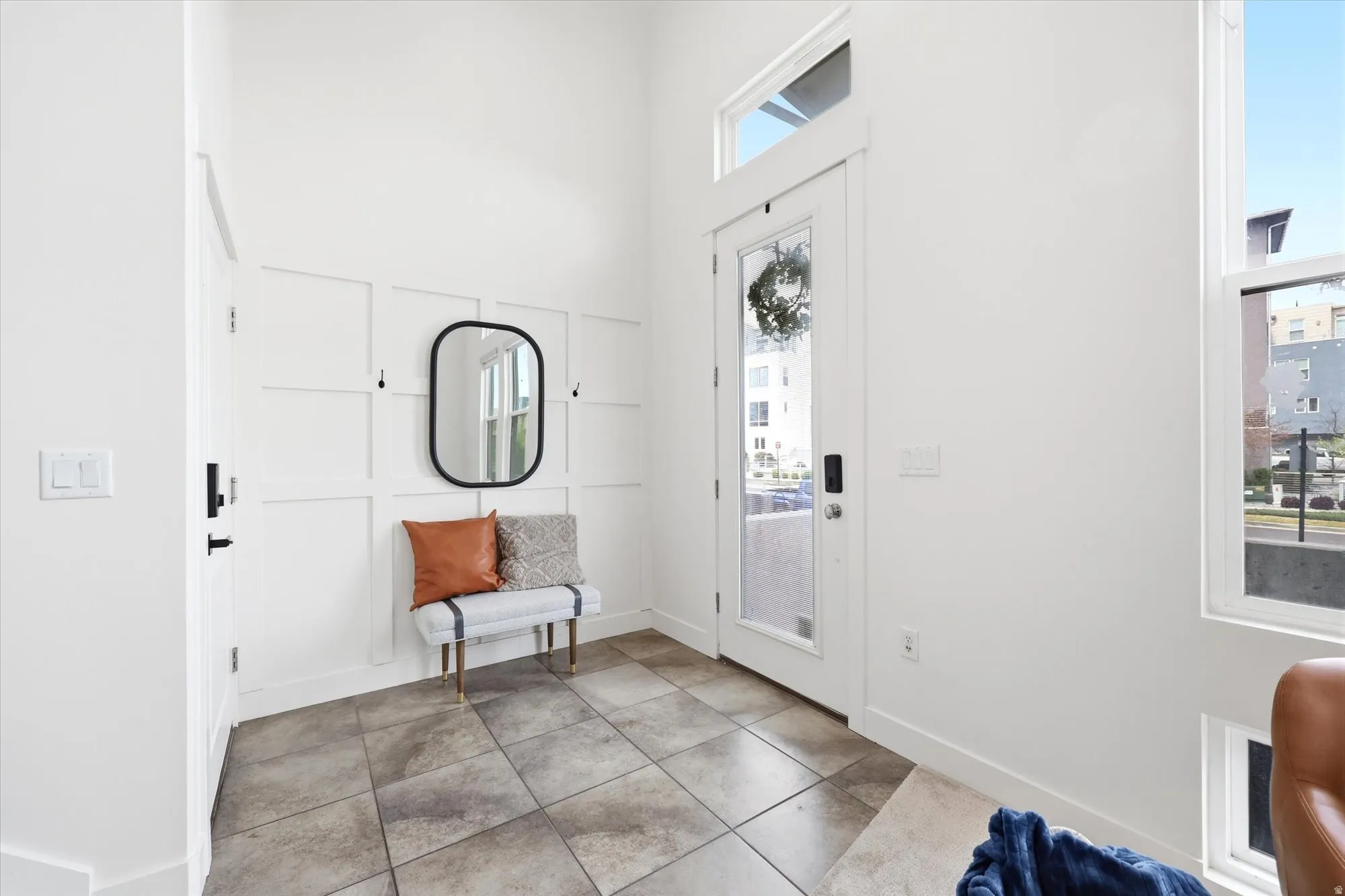 Foyer entrance featuring light tile patterned flooring and a high ceiling