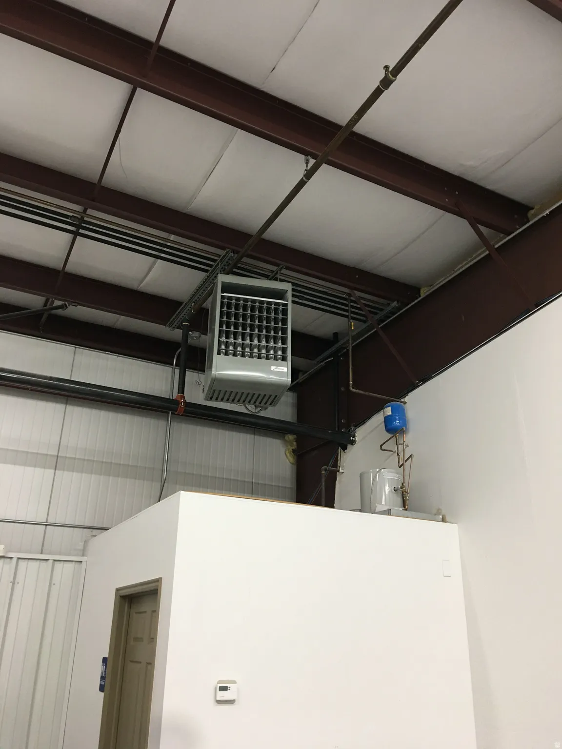 Garage view of a heating unit and metal wall