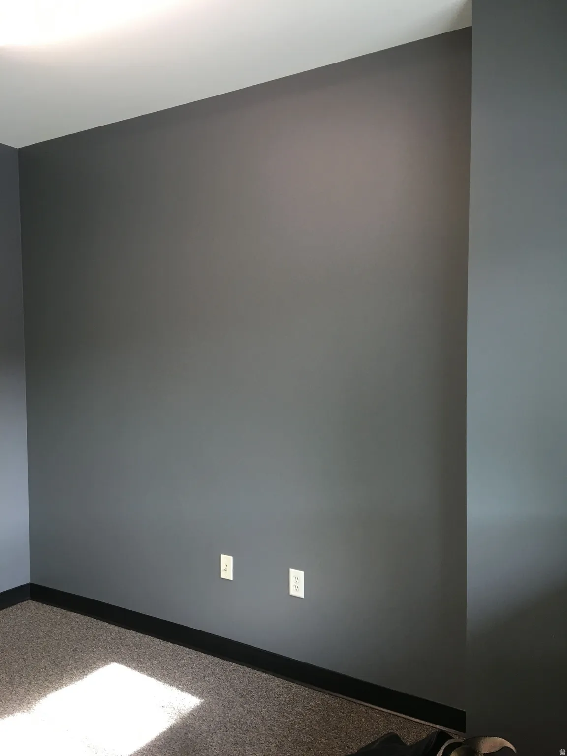 Empty room featuring baseboards and light carpet
