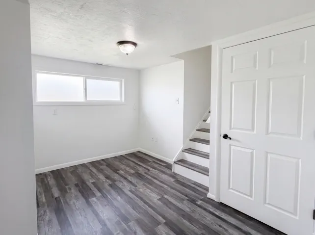 Unfurnished room with dark wood finished floors and a textured ceiling