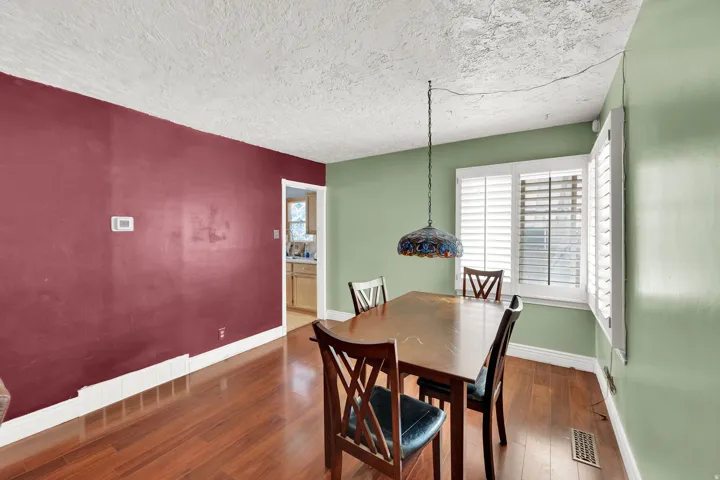 Dining space with hardwood / wood-style flooring and a textured ceiling