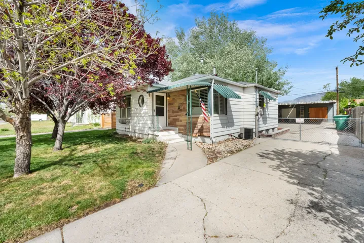 View of front of house featuring a front lawn, an outdoor structure, and driveway
