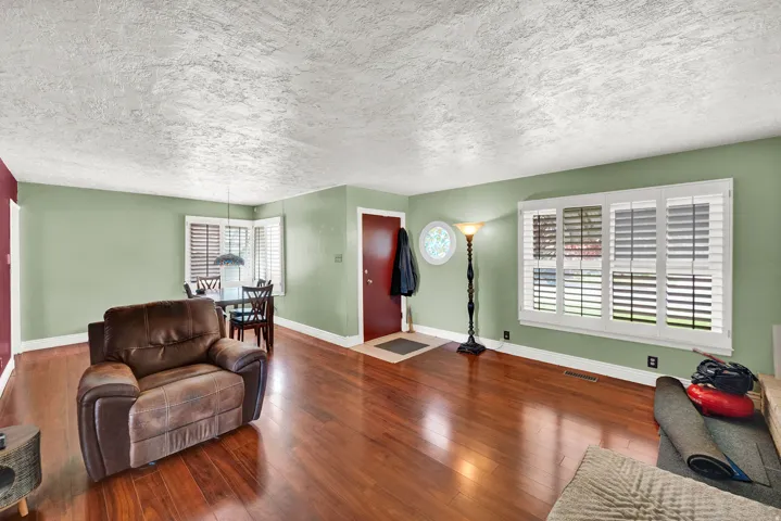 Living room featuring a textured ceiling and dark wood-style floors