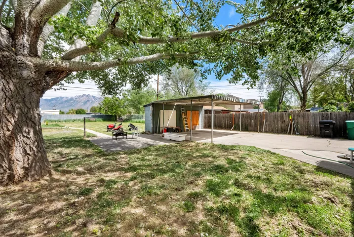 Fenced backyard with a patio area and an outbuilding