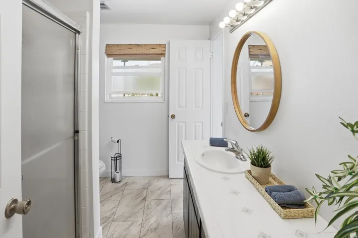 Full bathroom featuring vanity, a stall shower, and light marble finish flooring