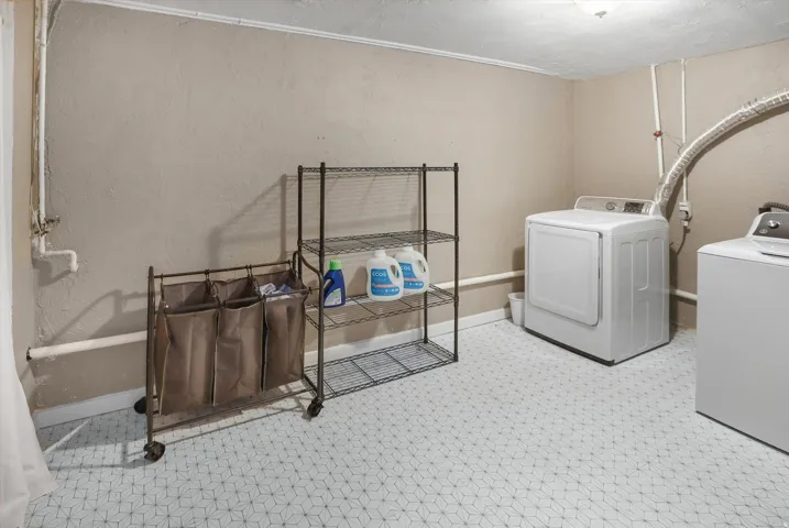 Laundry area with separate washer and dryer and a textured wall