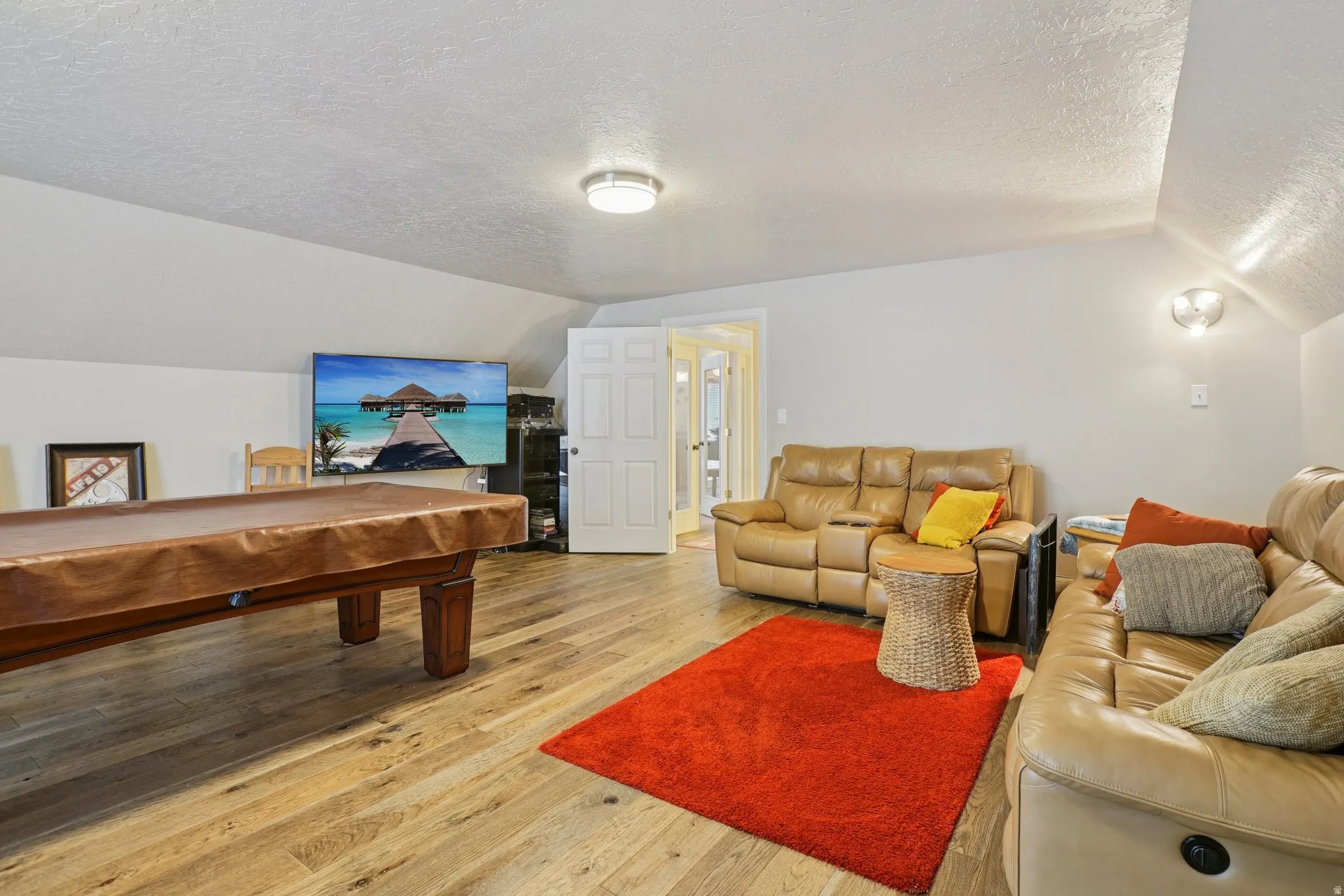 Game room featuring a textured ceiling, pool table, and hardwood / wood-style flooring