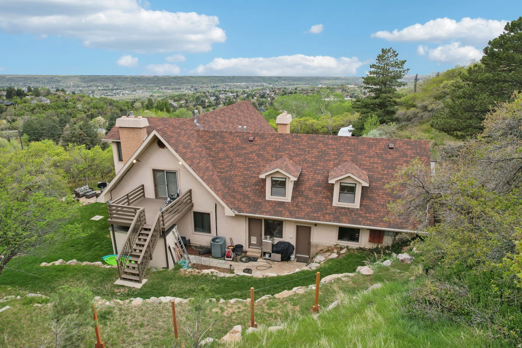 Rear view of property with a chimney, a patio area, roof with shingles, and a lawn