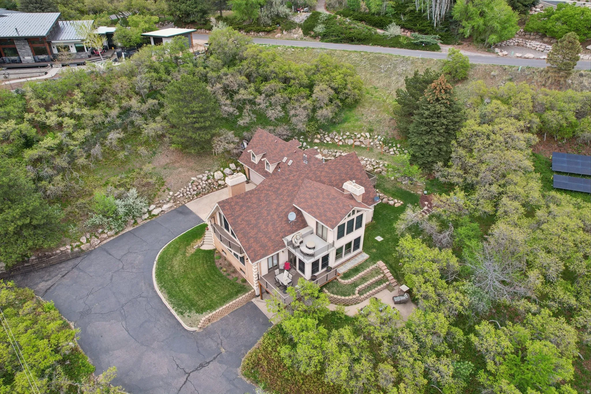 Aerial view of property and surrounding area featuring a tree filled landscape